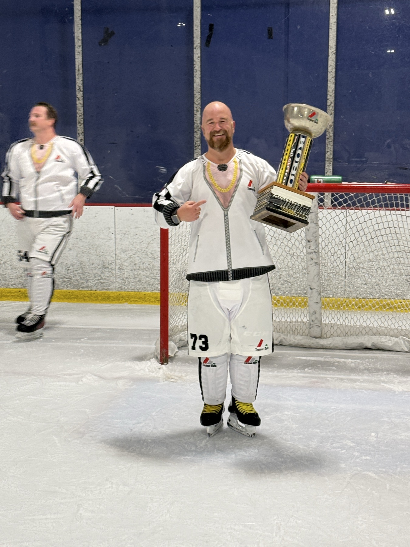 Track Suit Mafia player in the white tracksuit uniform holding a trophy